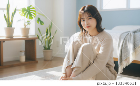 自然光あふれる白い部屋で過ごす穏やかな女性のポートレート 133340611