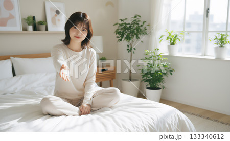 自然光あふれる白い部屋で過ごす穏やかな女性のポートレート 133340612