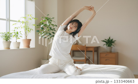 朝の光の中で膝立ちする若い女性のライフスタイルポートレート 133340663