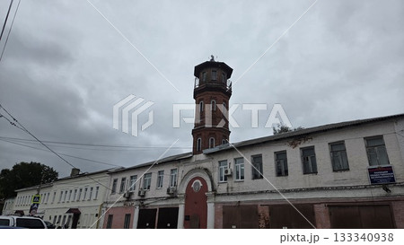 Old Fire station with watchtower. Historic brick tower and building in Pavlovsky Posad, Russia on overcast day 133340938