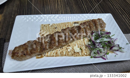 Traditional georgian cuisine: grilled meat with onions and fresh herbs on flatbread. Georgian kebab lamb with lavash Traditional georgian cuisine: grilled meat with onions and fresh herbs on flatbread. Georgian kebab lamb with lavash 133341002