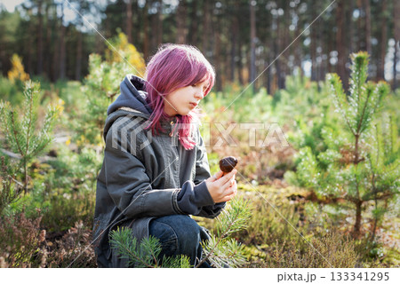 Girl with pink hair exploring mushroom in forest Girl with pink hair exploring mushroom in forest 133341295