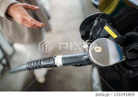 Person fueling car with diesel at gas station 133341604