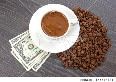 A white cup filled with freshly brewed coffee sits on a saucer 133342114