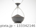 Minimalist hourglass with black sand trickling down on a white backdrop 133342146