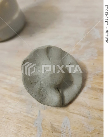 Hand-Formed Gray Clay Piece on Wooden Surface dumpling 133342613