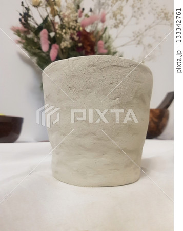 Textured Clay Pot with Dried Flowers Background 133342761