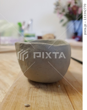 Rustic Clay Bowl: Handmade Pottery Art on Wood 133342770