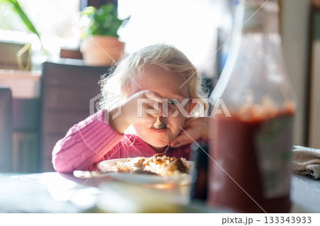 little girl eating pizza in the cafe 133343933