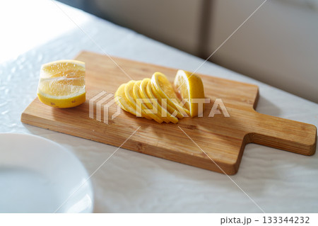 lemon slices on cutting board on wooden board lemon slices on cutting board on wooden board 133344232