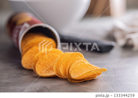 Crispy potato chips on kitchen table. 133344259