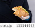 Close-Up of Pistachio Croissant Held in Hand 133344542