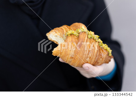 Close-Up of Pistachio Croissant Held in Hand 133344542