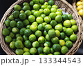 Fresh Green Limes in Wicker Basket 133344543