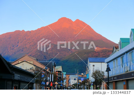 【大分県】夕日を浴びる由布岳と由布院駅前 133344837