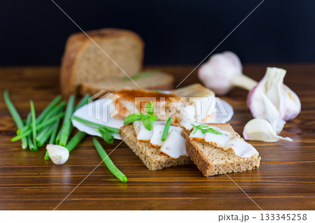 Black bread with lard and onions on a wooden table Black bread with lard and onions on a wooden table 133345258