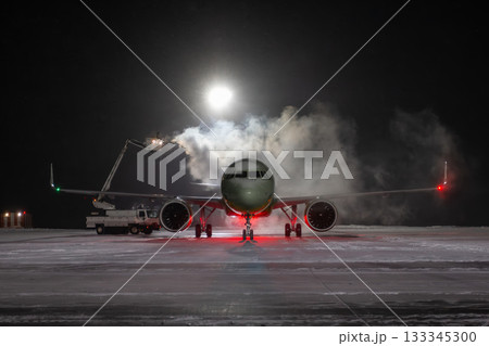 Ground deicing of a passenger jetliner on the night airport at winter Ground deicing of a passenger jetliner on the night airport at winter 133345300