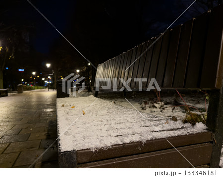 Bench covered in snow and frozen solid. Frozen seat in city park on cold evening. Bad weather with sub zero temperatures. Seat is covered in fresh frozen snow, making it impossible to sit in park 133346181