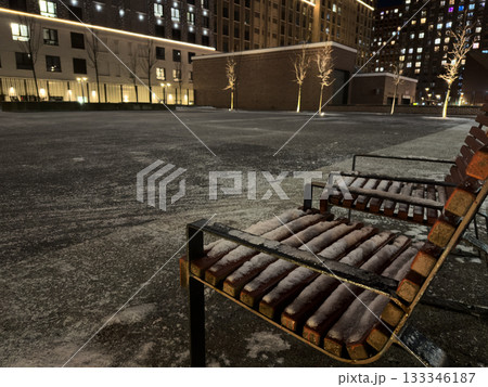 The first snow on a frosty evening covered the seats in the pedestrian area near the residential complex. An evening stroll was impossible to sit on because of the snow covering the benches The first snow on a frosty evening covered the seats in the pedestrian area near the residential complex. An evening stroll was impossible to sit on because of the snow covering the benches 133346187