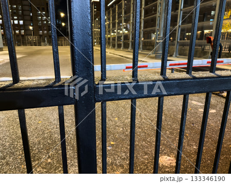 Black metal gates and a barrier in the evening parking lot. Closed access for cars to private property. Concept of a closed area and blocked access for cars Black metal gates and a barrier in the evening parking lot. Closed access for cars to private property. Concept of a closed area and blocked access for cars 133346190