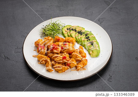 Crispy shrimp bites with spicy mayo, avocado slices and microgreens on a white plate Crispy shrimp bites with spicy mayo, avocado slices and microgreens on a white plate 133346389