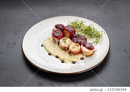 Chicken bacon roulade with berry sauce and creamy puree, plated with microgreens Chicken bacon roulade with berry sauce and creamy puree, plated with microgreens 133346394