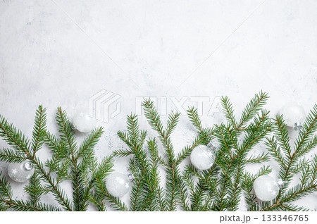 Fir branches with a ball-shaped Christmas tree ornaments on a light textured background. Fir branches with a ball-shaped Christmas tree ornaments on a light textured background. 133346765