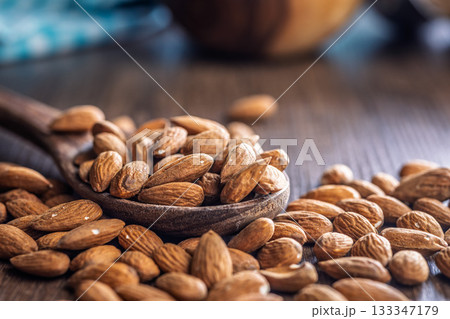 Almond kernel nuts on spoon on wooden table. Almond kernel nuts on spoon on wooden table. 133347179
