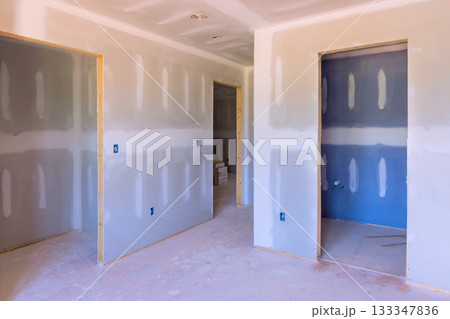 Unfinished interior features drywall, new door openings, clean construction site in residential building. Unfinished interior features drywall, new door openings, clean construction site in residential building. 133347836
