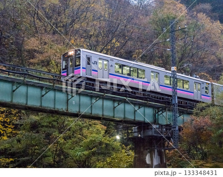 【田沢湖線】紅葉する渓谷を通過する普通列車 133348431