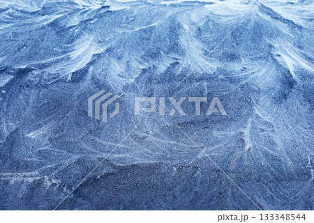 Frosty Patterns. Close-up of intricate frost designs on a blue surface, Frosty Patterns. Close-up of intricate frost designs on a blue surface, 133348544