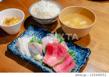 マグロ・アジ・イカの刺身と味噌汁、ごはんを添えた家庭的な夕食 マグロ・アジ・イカの刺身と味噌汁、ごはんを添えた家庭的な夕食 133348551