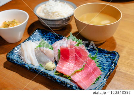 マグロ・アジ・イカの刺身と味噌汁、ごはんを添えた家庭的な夕食 マグロ・アジ・イカの刺身と味噌汁、ごはんを添えた家庭的な夕食 133348552