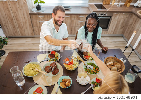 Joyful dinner gathering with friends in a cozy kitchen Joyful dinner gathering with friends in a cozy kitchen 133348901