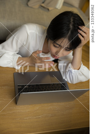 夜リビングでパソコンを見る若い女性 夜リビングでパソコンを見る若い女性 133349362