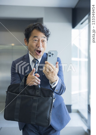 スマートフォンを見て驚くビジネスマン　 133349454