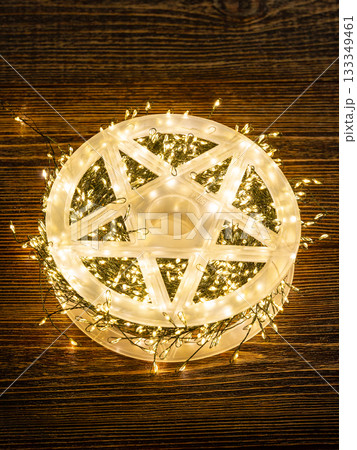Garland of yellow LEDs on a brown wooden background. Garland of yellow LEDs on a brown wooden background. 133349461