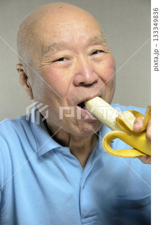 完熟バナナを笑顔で食べる老人 133349836