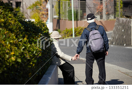 冬の朝の住宅街で散歩するシニア夫婦の姿 133351251