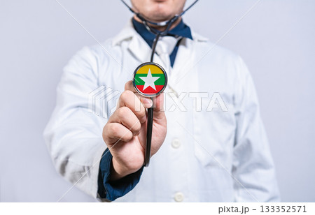 Doctor hands holding stethoscope with Myanmar flag. Myanmar health and care concept Doctor hands holding stethoscope with Myanmar flag. Myanmar health and care concept 133352571