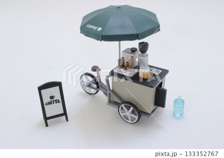Mini Coffee Cart With Umbrella and Playful Miniature Figures in Street Scene Mini Coffee Cart With Umbrella and Playful Miniature Figures in Street Scene 133352767