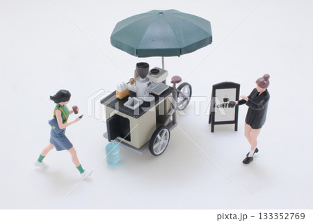 Mini Coffee Cart With Umbrella and Playful Miniature Figures in Street Scene 133352769