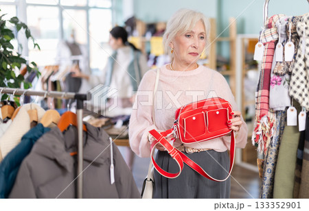 Mature woman choosing a fashionable handbag in store clothes 133352901