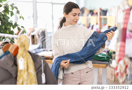 Armenian woman buys stylish jeans in a clothing store 133352912