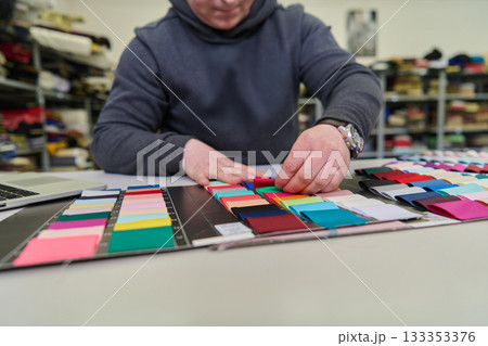 Fashion designer selecting fabric swatches, color palette and textile samples, material choice for clothing design, textile industry, creative process, interior design. 133353376