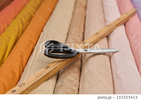 Fabric rolls with scissors and ruler, product photo, studio shot, colorful textile rolls, sewing and tailoring concept, fashion design and dressmaking, textile industry, material selection Fabric rolls with scissors and ruler, product photo, studio shot, colorful textile rolls, sewing and tailoring concept, fashion design and dressmaking, textile industry, material selection 133353413