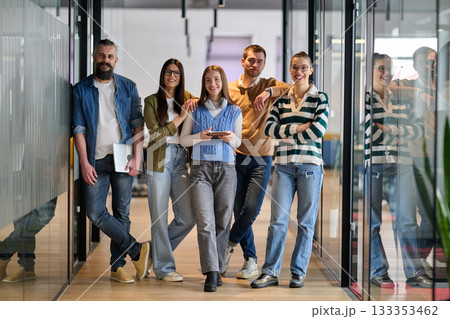 Group of young business team walking together through a modern office hallway, smiling and discussing work. Concept of confidence, teamwork, leadership, and positive workplace culture. Group of young business team walking together through a modern office hallway, smiling and discussing work. Concept of confidence, teamwork, leadership, and positive workplace culture. 133353462