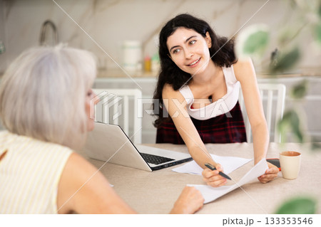Mature woman consulting with female real estate agent in home Mature woman consulting with female real estate agent in home 133353546