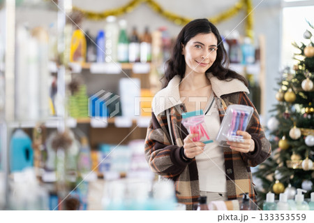 Woman buying a razor on the background of a Christmas tree Woman buying a razor on the background of a Christmas tree 133353559