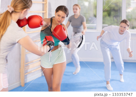 Teen girls in punch mitts boxing Teen girls in punch mitts boxing 133353747